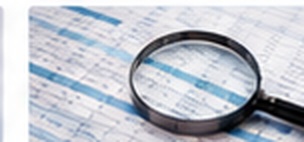 Magnifying glass over a spreadsheet representing investigation and analysis.